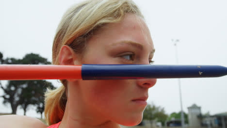 Close-up-of-Caucasian-female-athlete-practicing-javelin-throw-at-sports-venue-4k