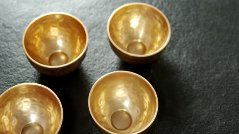 Golden-steel-bowls-on-concrete-background-4k