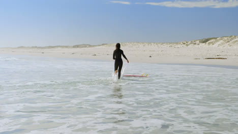 Woman-running-towards-surfboard-on-the-sea-4k