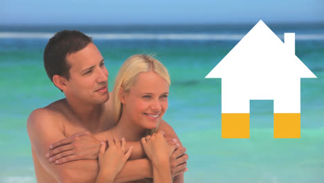 Holiday-couple-embrace-by-the-sea-while-house-icon-fills-yellow