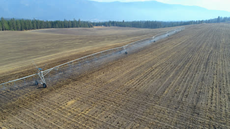 Aerial-view-of-irrigation-sprinkles-used-in-harvested-field-4k