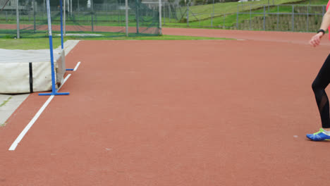Side-view-of-Caucasian-female-athlete-practicing-javelin-throw-at-sports-venue-4k