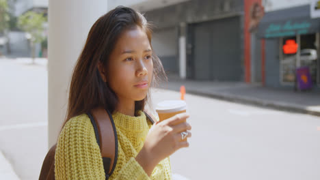 Teenage-girl-drinking-coffee-on-street-4k