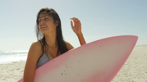 Surfista-Femenina-Con-Tabla-De-Surf-Jugando-Con-Su-Cabello-Mojado-4k-4k
