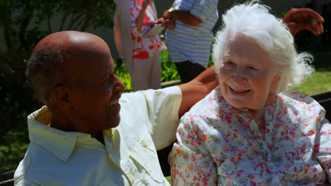 Front-view-of-active-mixed-race-senior-couple-embracing-each-other-in-the-garden-of-nursing-home-4k