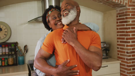 Afroamerikanisches-Seniorenpaar-Umarmt-Sich-In-Der-Küche-Zu-Hause