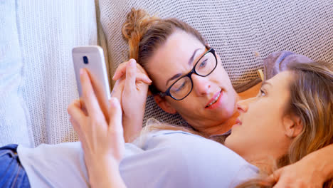 Lesbisches-Paar-Interagiert-Miteinander,-Während-Es-Das-Mobiltelefon-4k-Benutzt
