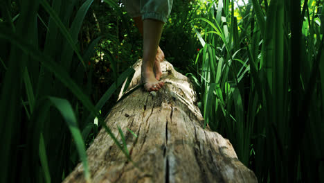 Woman-walking-over-a-wooden-log-in-the-park-4k