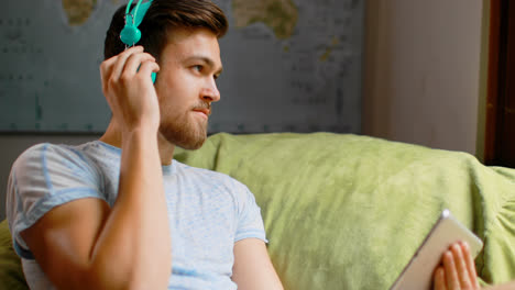 Man-listening-music-on-digital-tablet-at-home-4k