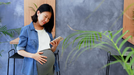 Mujer-Embarazada-Usando-Teléfono-Móvil-En-La-Oficina-4k