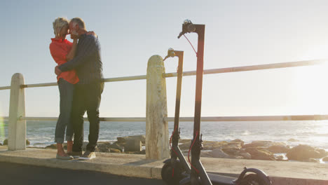 Senior-couple-embracing-each-other-alongside-beach