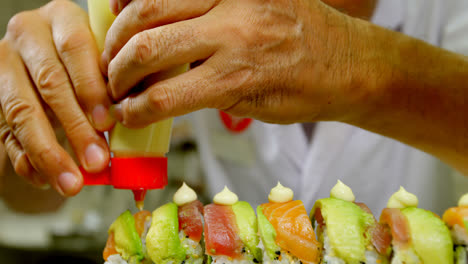 Männlicher-Koch,-Der-Soße-Auf-Sushi-In-Der-Küche-4k-Belegt