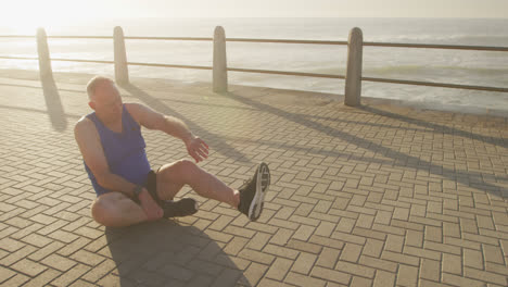 Senior-man-stretching-his-legs-on-the-promenade