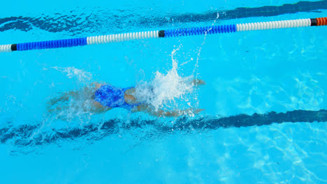 Vista-De-ángulo-Alto-De-Una-Joven-Nadadora-Nadando-Dentro-De-La-Piscina-4k