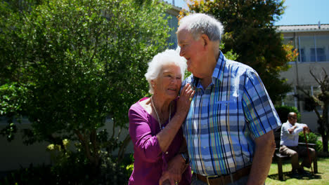 Front-view-of-active-Caucasian-senior-couple-walking-in-the-garden-of-nursing-home-4k