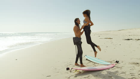 Surfer-couple-having-fun-on-the-beach-4K-4k