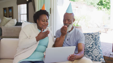 Happy-senior-african-american-couple-wearing-party-hats
