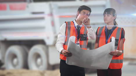 Two-Caucasian-workers-wearing-an-orange-high-vest-checking-their-plan-and-pointing-fingers-over-rays