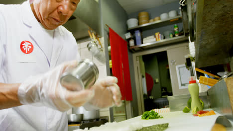 Male-chef-preparing-rice-roll-in-kitchen-4k