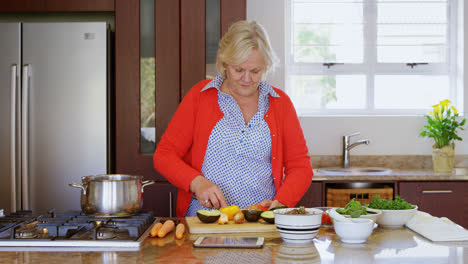 Senior-woman-chopping-vegetable-in-kitchen-4k