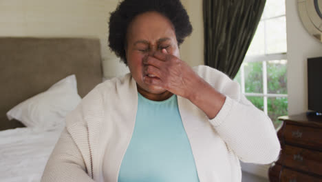 African-american-senior-woman-sneezing-on-her-elbow