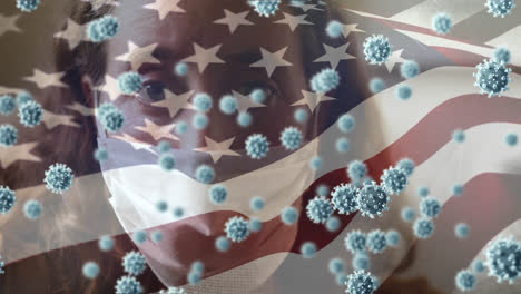 Covid-19-cells-and-Woman-wearing-face-mask-against-US-flag-waving