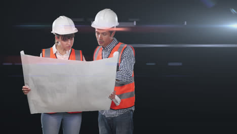 Two-Caucasian-workers-wearing-an-orange-high-vest-and-hat-holding-a-plan-in-a-dark-background