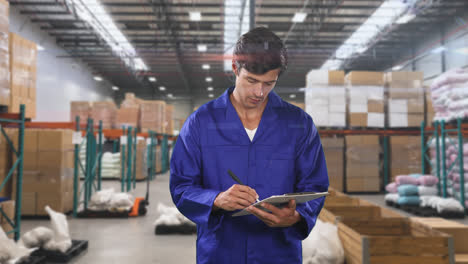 Caucasian-male-worker-in-a-warehouse-area-checking-notes-and-smiling-at-the-camera