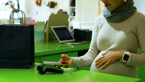 Pregnant-woman-paying-bill-at-counter-4k