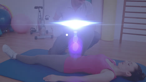 Animation-of-glowing-light-over-woman-exercising-with-fitness-instructor