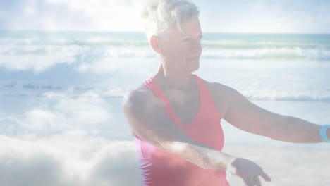 Animation-Von-Leuchtendem-Licht-über-Einer-Glücklichen-älteren-Frau,-Die-Am-Meer-Yoga-Praktiziert