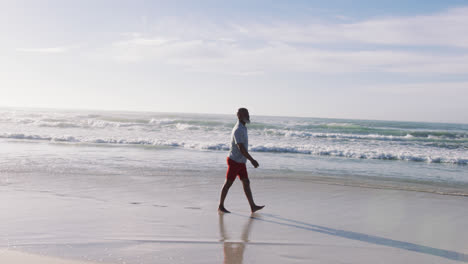 Hombre-Afroamericano-Mayor-Caminando-En-La-Playa