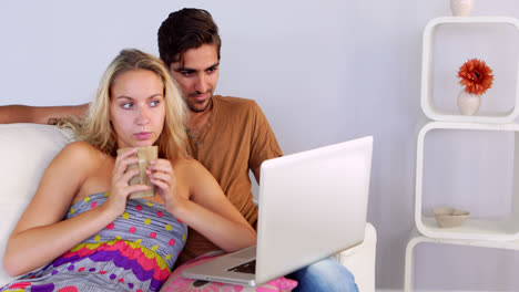 Bored-couple-watching-the-laptop-on-the-couch