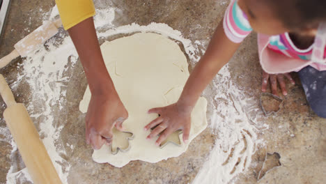 African-american-mother-and-daughter-using-cookie-cutters-in-kitchen