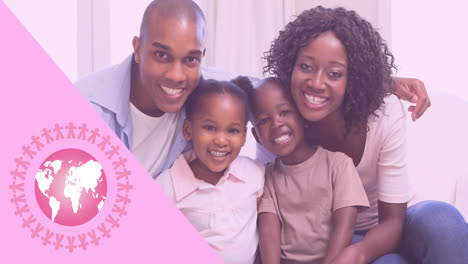 Animation-of-pink-globe-logo-with-breast-cancer-text-over-smiling-family-indoors