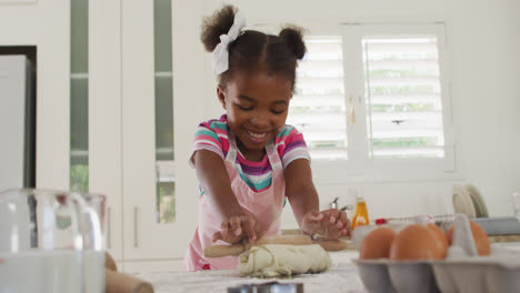 Glückliches-Afroamerikanisches-Mädchen,-Das-Teig-In-Der-Küche-Rollt