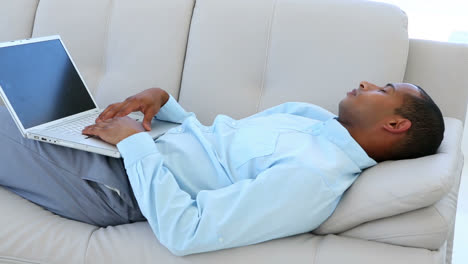 Businessman-falling-asleep-on-the-couch-with-laptop
