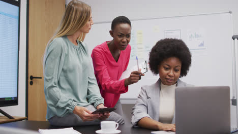 Drei-Unterschiedliche-Geschäftsfrauen-Diskutieren-Mit-Laptop-Und-Tablet-In-Einem-Büro