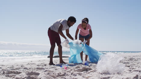 Pareja-Afroamericana-Recogiendo-Residuos-Plásticos-En-La-Playa