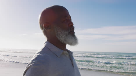 Älterer-Afroamerikanischer-Mann-Steht-Am-Strand,-Bewundert-Die-Aussicht-Und-Schließt-Die-Augen