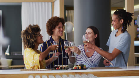 Diverse-group-of-happy-friends-raising-glasses-making-a-toast-at-a-bar