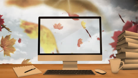 Desktop-Computer-Und-Bürogeräte-Auf-Einem-Tisch-Vor-Herbstlichen-Ahornblättern,-Die-Im-Blauen-Himmel-Schweben