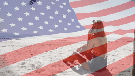 Animation-of-american-flag-waving-over-woman-talking-on-smartphone-on-beach