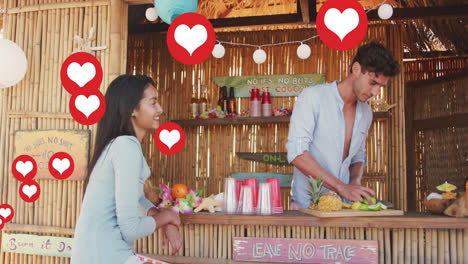 Animation-of-red-heart-love-digital-icons-over-smiling-woman-and-man-in-beach-bar