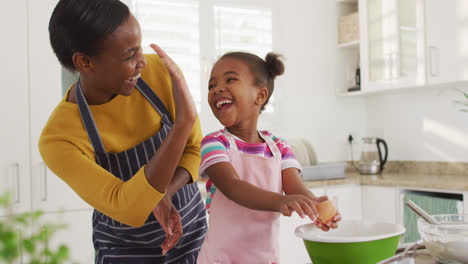 Glückliche-Afroamerikanische-Mutter-Und-Tochter-Kochen-Und-Geben-High-Five-In-Der-Küche