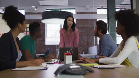Mixed-race-businesswoman-having-a-meeting-with-colleagues-in-meeting-room