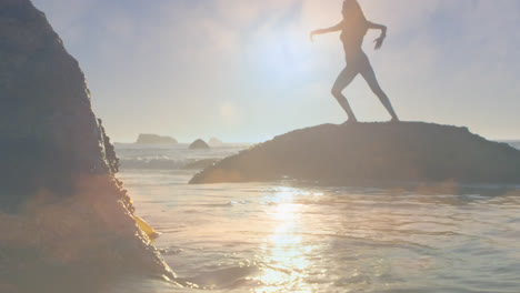 Silhouette-Einer-Frau,-Die-An-Einem-Sonnigen-Tag-Yoga-Auf-Einem-Felsen-Am-Meer-Praktiziert