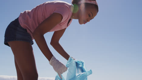 Mujer-Afroamericana-Recogiendo-Residuos-Plásticos-En-La-Playa.