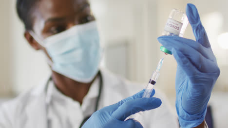 Afroamerikanische-Ärztin-Trägt-Gesichtsmaske-Und-Bereitet-Den-Covid-Impfstoff-Für-Den-Patienten-Vor