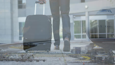 Digital-composite-video-of-airplane-flying-against-mid-section-of-man-with-trolley-bag-walking